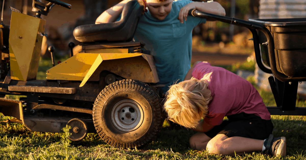 kids installing hitch on riding mower